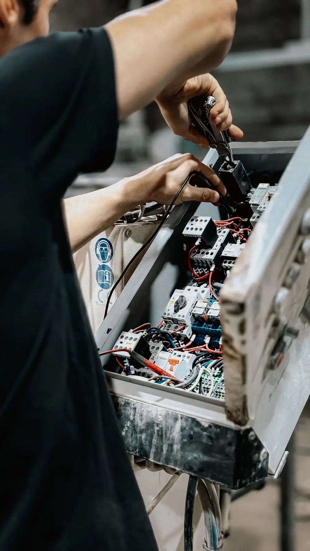 Commercial electrician checking control panel wiring